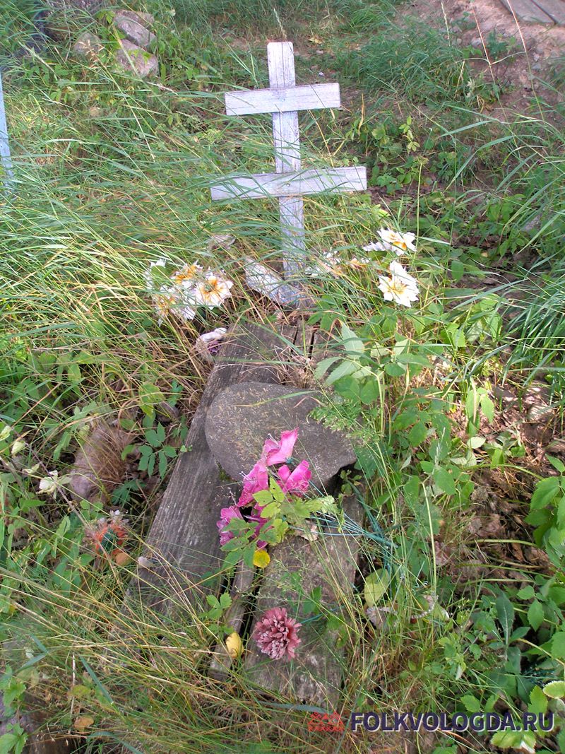 Могила с досками и камнем